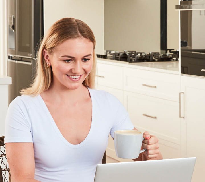Ariarne Titmus with a cup of coffee in hand.
