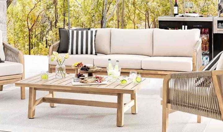 Seating and an outdoor kitchen set up outdoors in autumn.