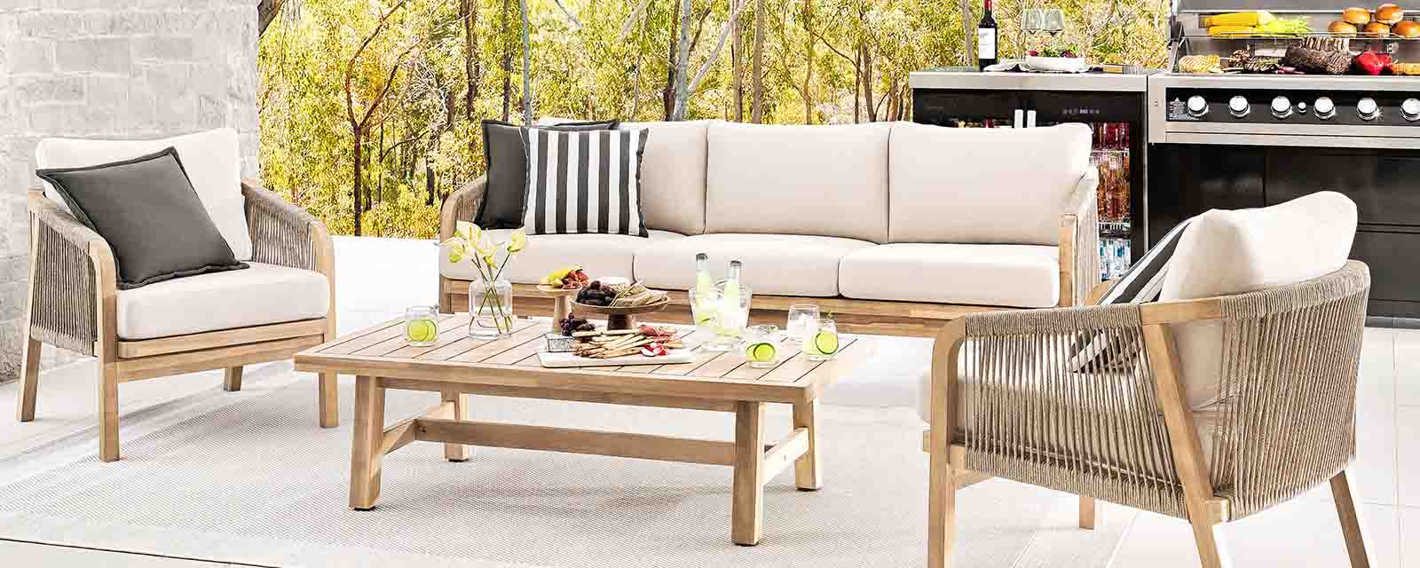 Seating and an outdoor kitchen set up outdoors in autumn.