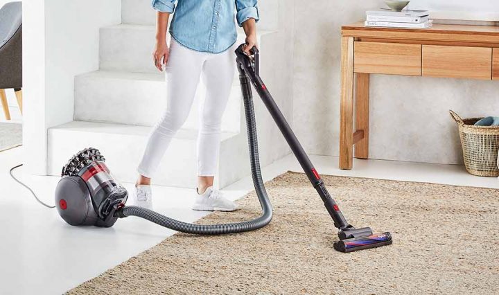 A person cleaning a rug with the Dyson Cinetic Big Ball Vacuum.