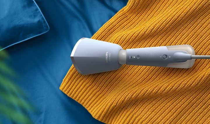 Image of the Philips 5000 Series Handheld Garment Steamer laying on a knitted jumper.