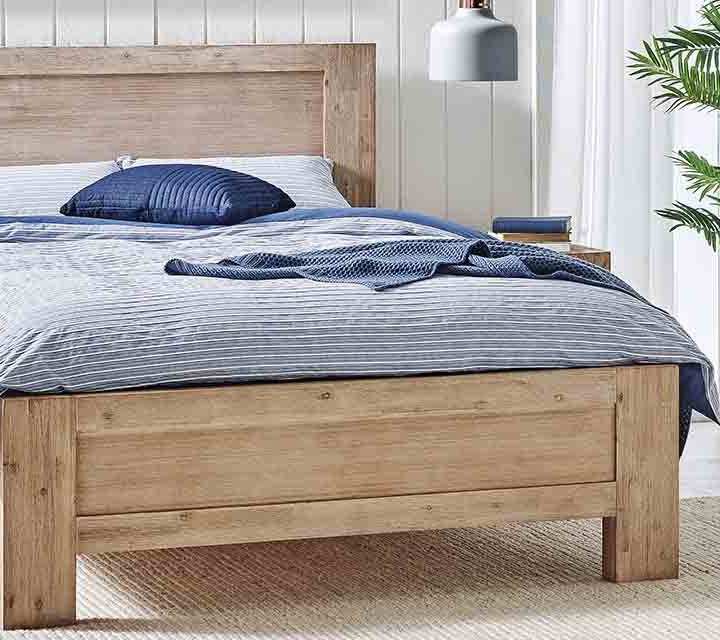 Complementary timber bed, tallboy and bedside table in a bedroom.
