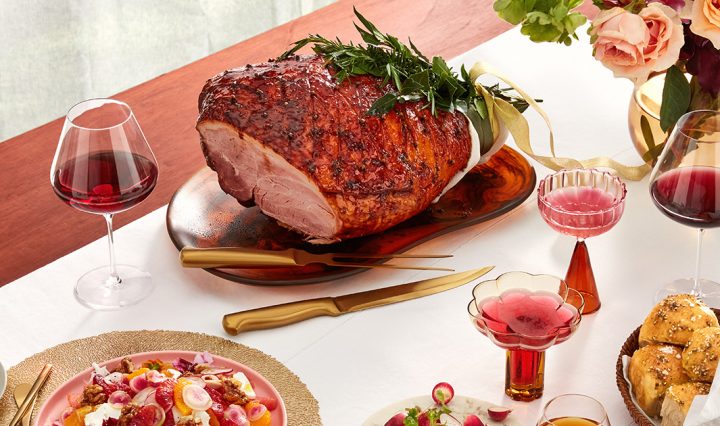A Christmas dinner or lunch spread with a large glazed ham and a selection of sides.
