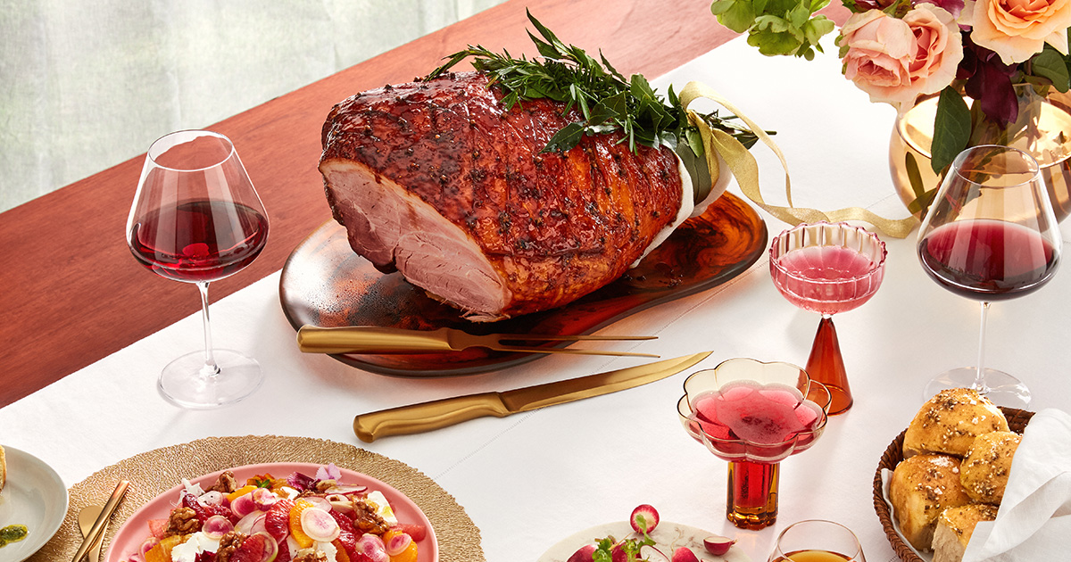A Christmas dinner or lunch spread with a large glazed ham and a selection of sides.