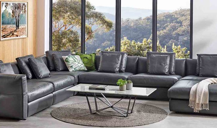 A Leather Lounge in front of a window with a bush view.