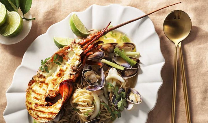 Lobster E-fu Noodle with Pippies and Cuttlefish on a tablecloth.