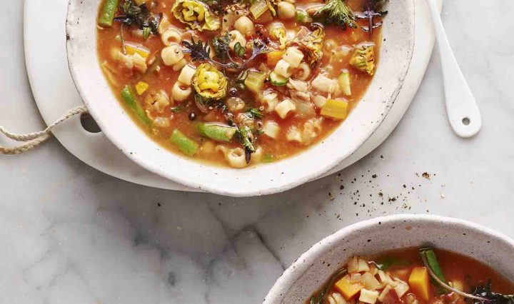 Two bowls of Minestrone with Pancetta, Zucchini Flowers and Baby Kale.