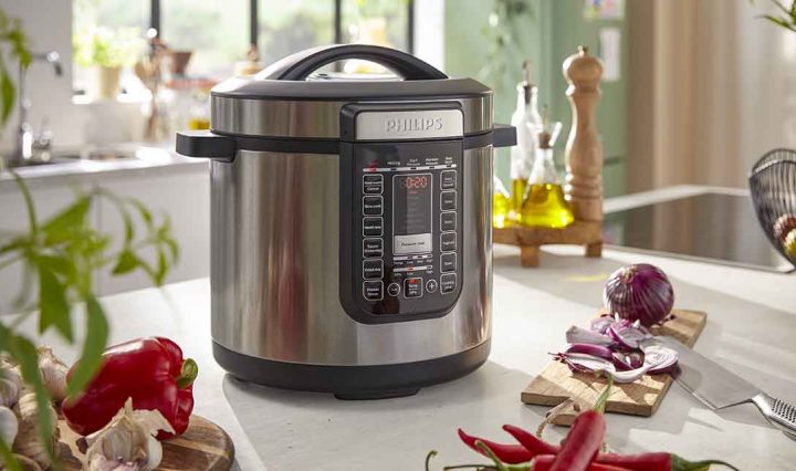 The Philips 8L All In One Cooker next to vegetables.