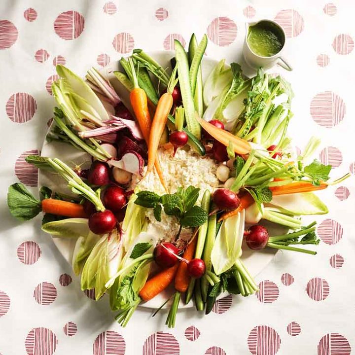 Raw vegetable plate with buttermilk ricotta and green sauce.
