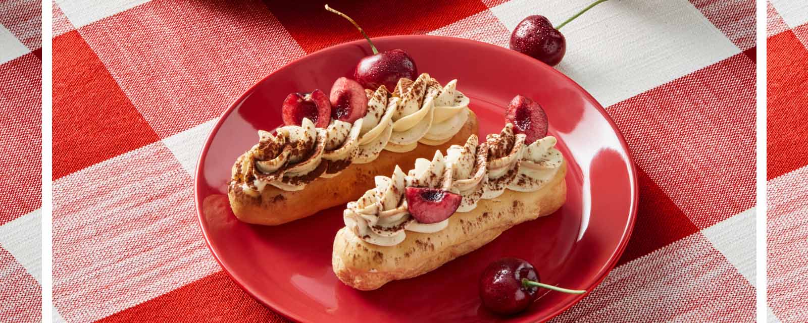 Cherry Mocha Eclairs on a red and white tablecloth.