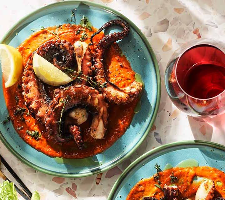 Grilled Octopus on plate with lemon.