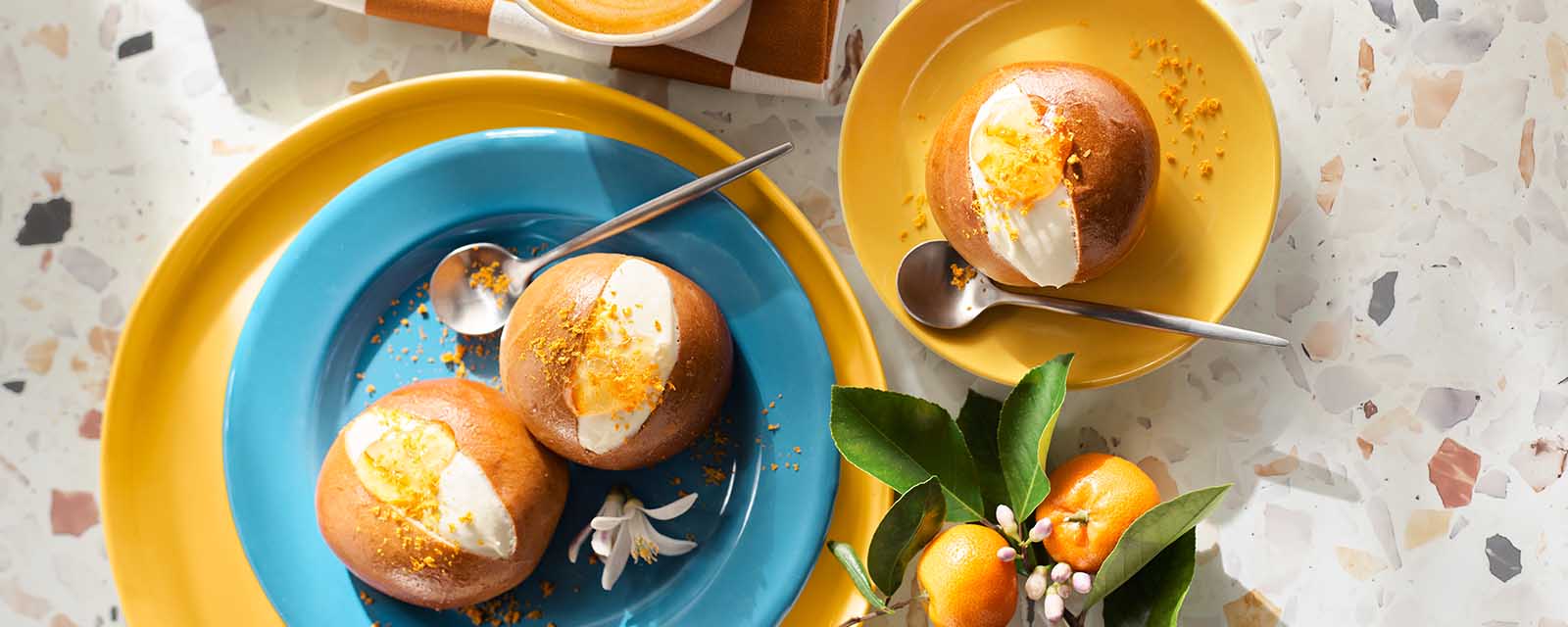 Garnished Maritozzi on blue and yellow plates.