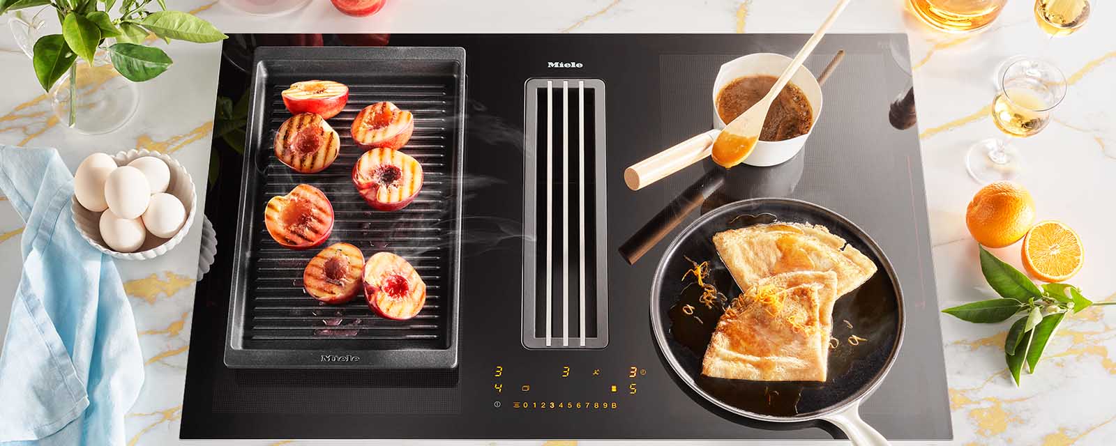Orange Crepe Suzette being cooked on a Miele 800mm 4 Zone Induction Cooktop with Vapour Extraction.