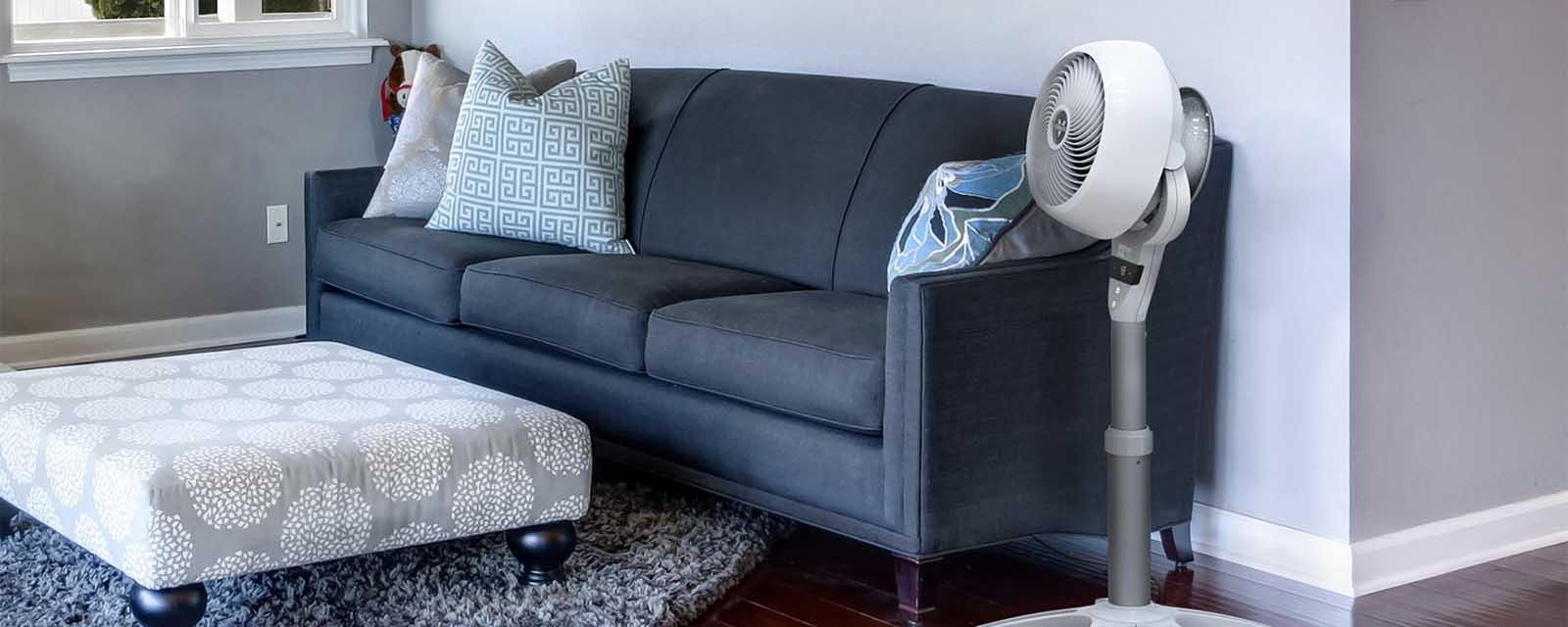 The Vornado’s Energy Smart™ Pedestal Air Circulator next to a couch.