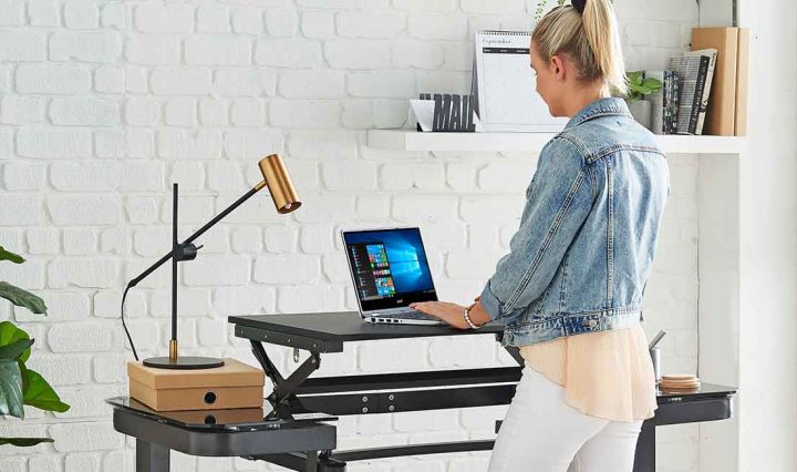 A person using a standing desk in their home office.