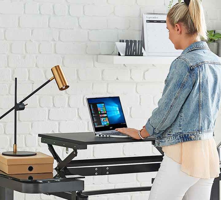 A person using a standing desk in their home office.