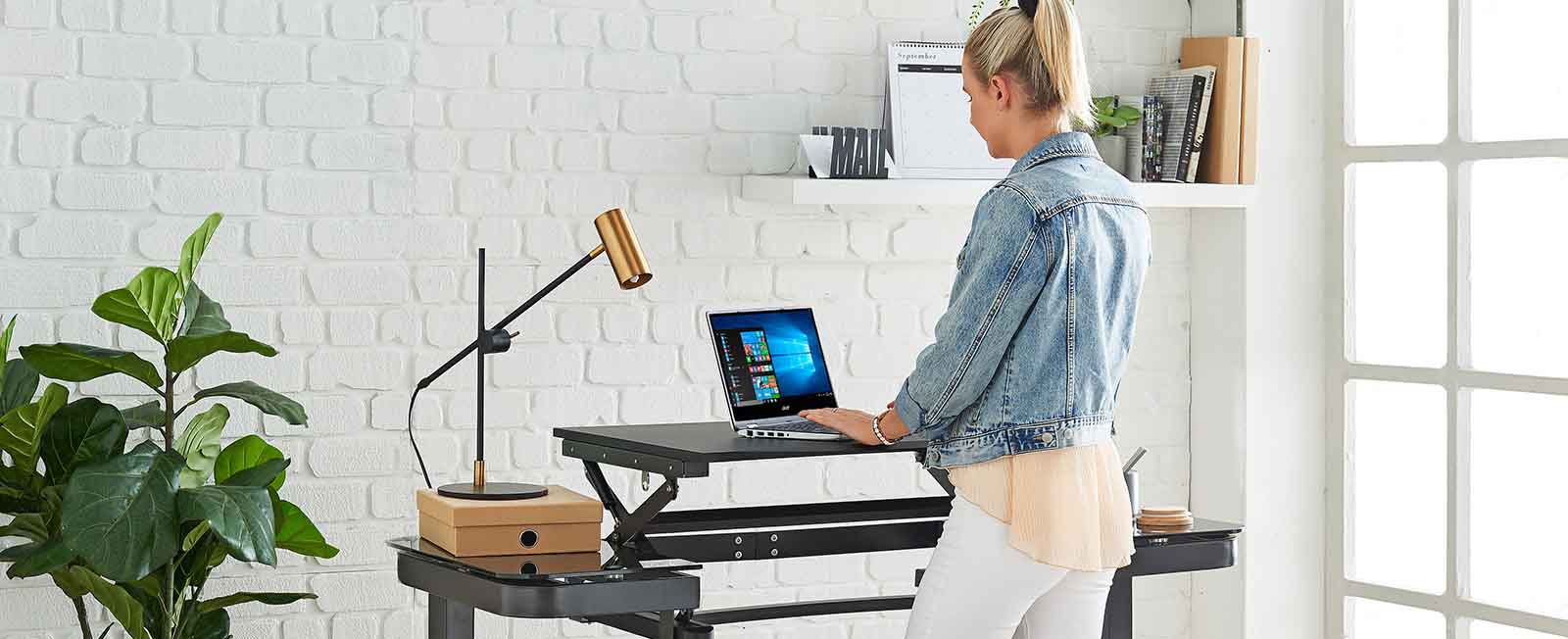 A person using a standing desk in their home office.