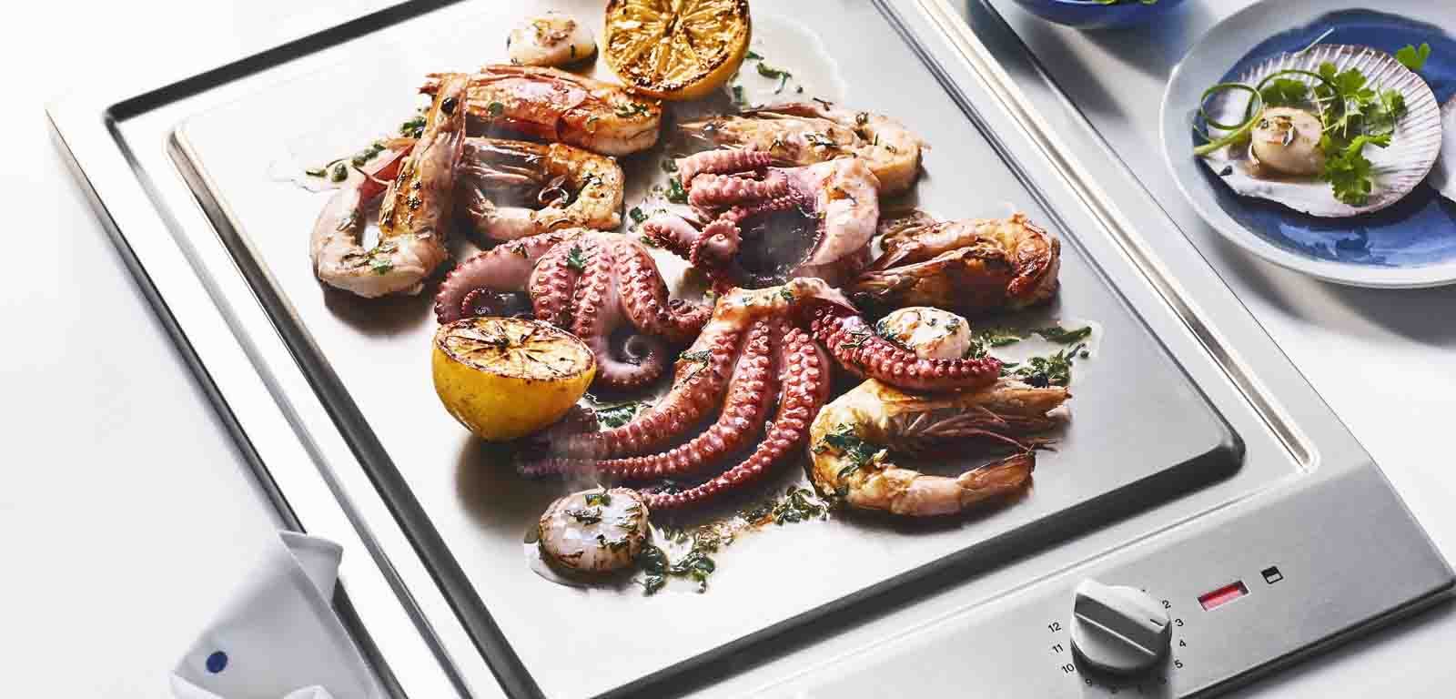 Using the Miele 38cm Cooktop Teppanyaki Grill to prepare our Summertime Seafood Platter with Oregano and Garlic Dressing.