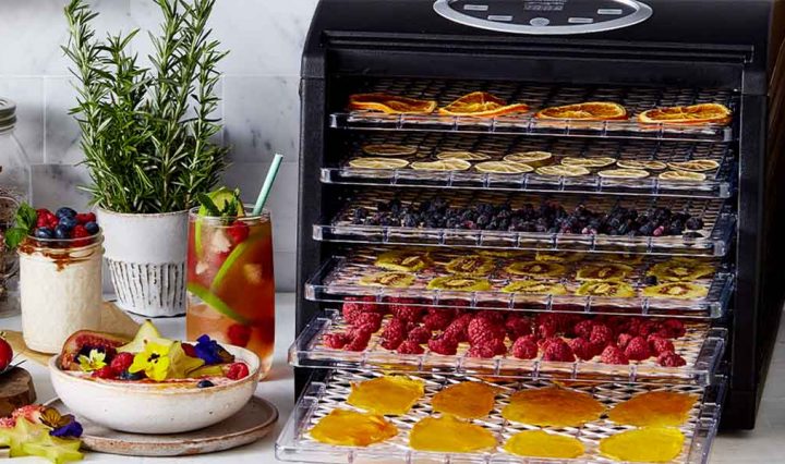 The Sunbeam Food Lab Electronic Dehydrator with various food on each shelf.