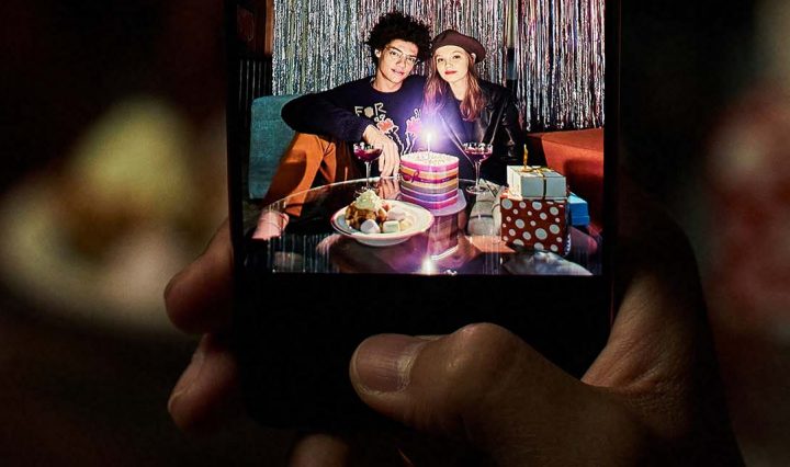 A person using a Samsung Galaxy to take a photo of people on their birthday.