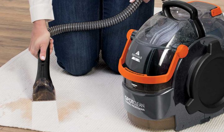 Using an appliance from the Bissell SpotClean range on a rug.