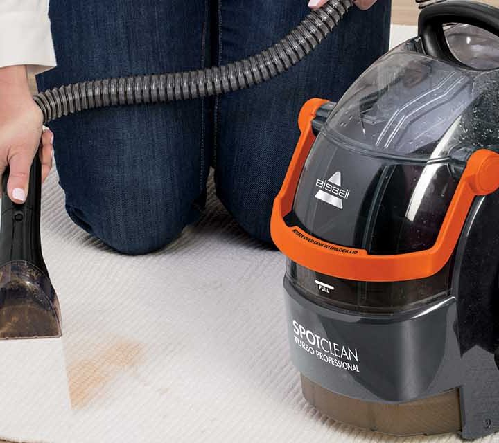 Using an appliance from the Bissell SpotClean range on a rug.