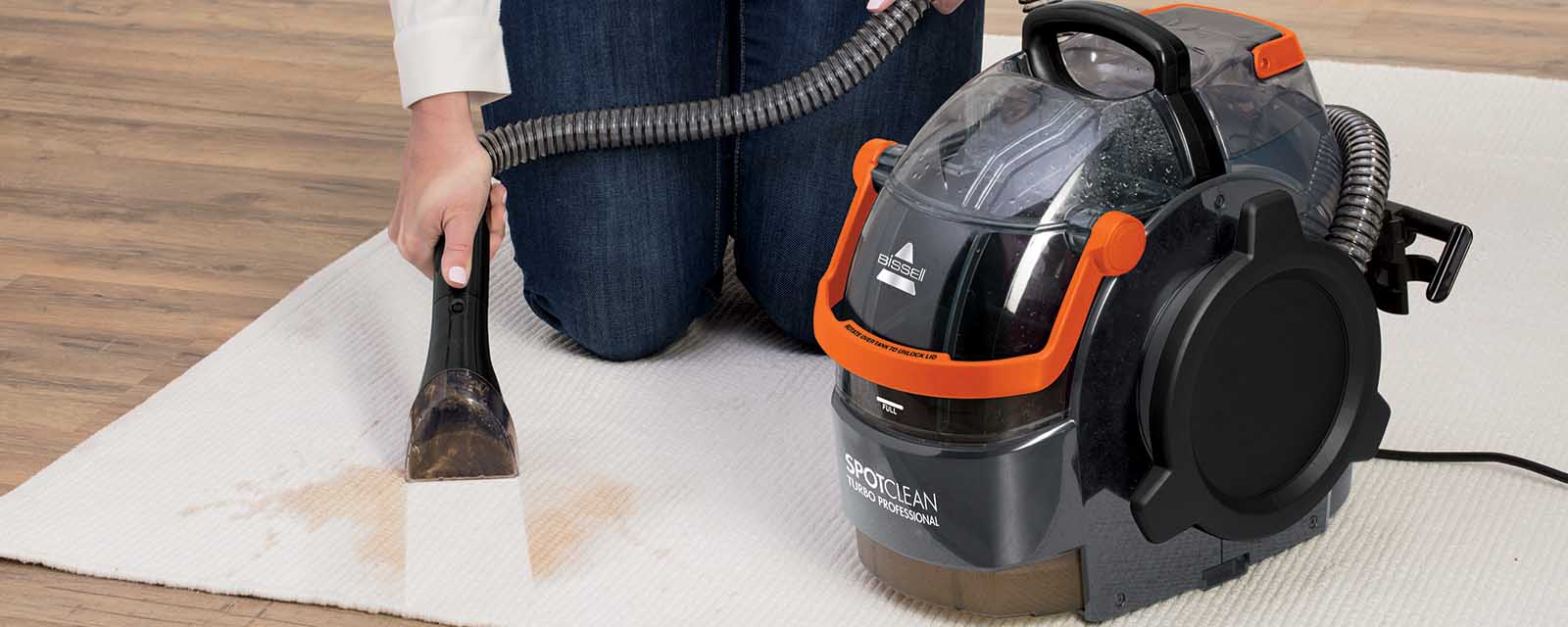 Using an appliance from the Bissell SpotClean range on a rug.