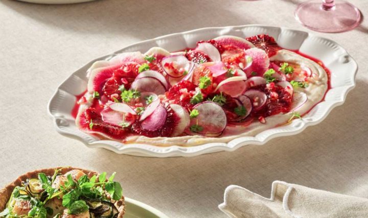 A white serving platter set on a cream table, showing the finished salad recipe ready to serve.